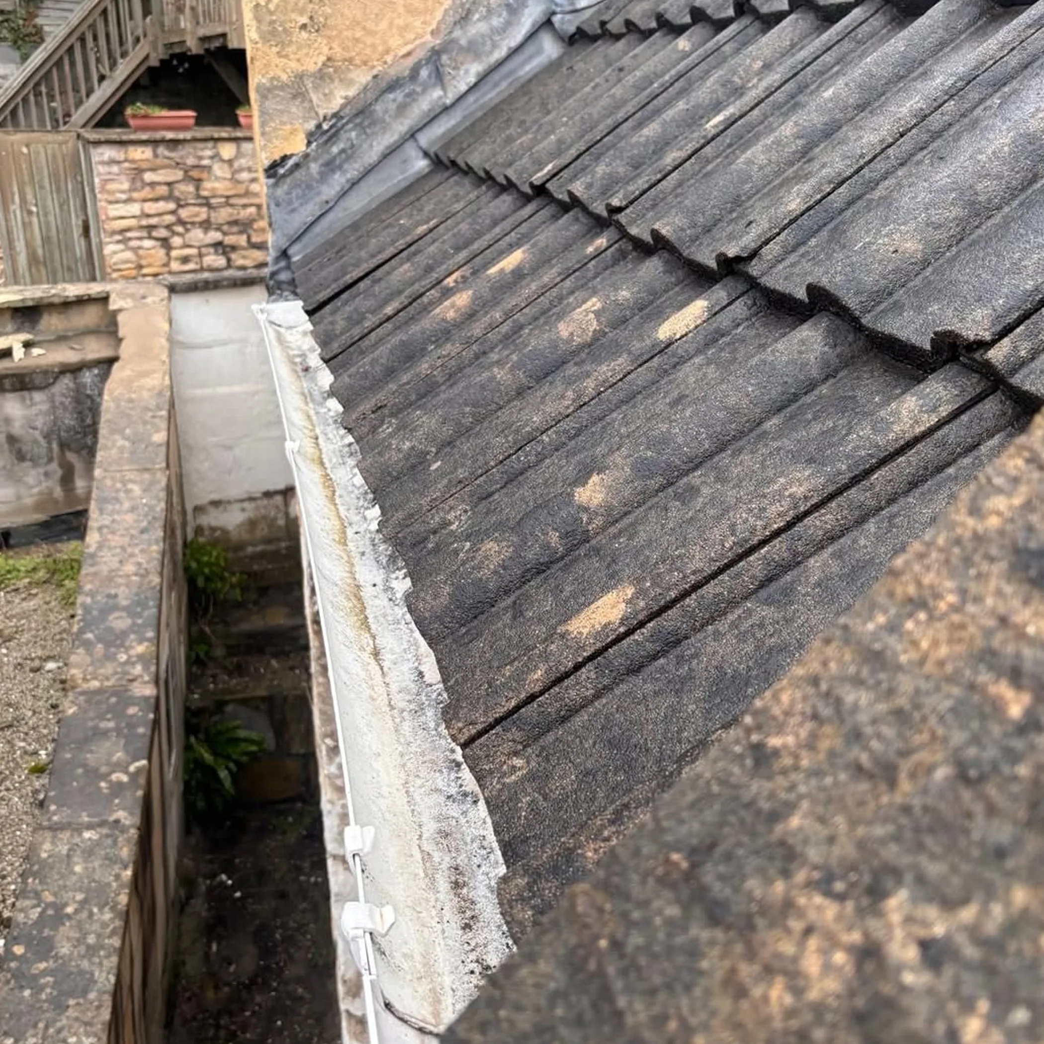 person cleaning a house gutter